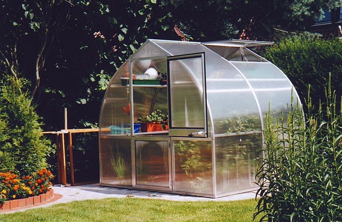 RIGA IIs Greenhouse with a durable aluminum frame, twin-wall polycarbonate panels for superior insulation, and a spacious design ideal for year-round gardening.