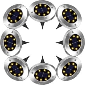 Rayolon solar ground lights installed in a garden pathway, emitting a soft and warm glow, designed for energy-efficient outdoor lighting with a sleek, low-profile design.