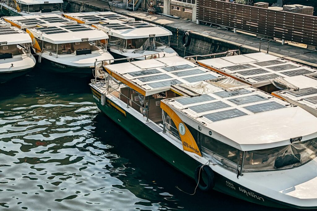 A fleet of solar-powered boats docked at an urban marina, showcasing green transportation.