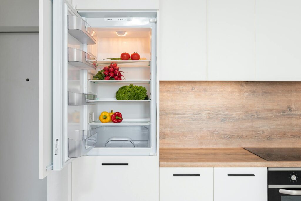 Energy-Efficient Open fridge in a sleek kitchen with fresh vegetables, perfect for healthy meals.