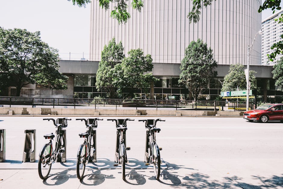 Row of bicycles parked in downtown Toronto, surrounded by modern architecture.
