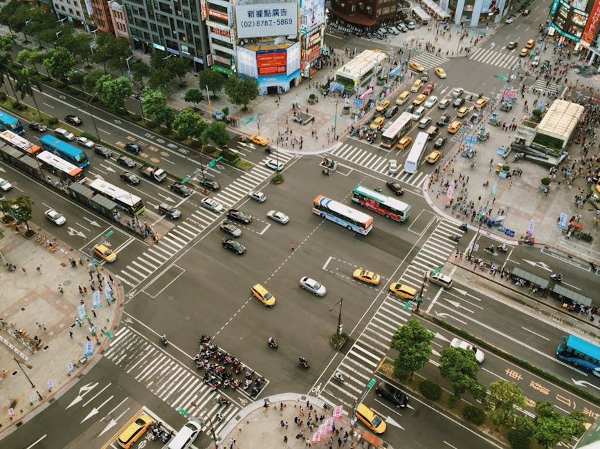 Aerial view showcasing busy city street life with traffic and pedestrians at an intersection.