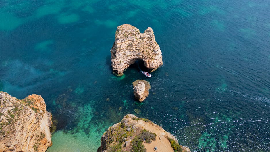Stunning aerial view of rocky cliffs and turquoise sea near Faro, Portugal. Perfect for travel and nature enthusiasts.